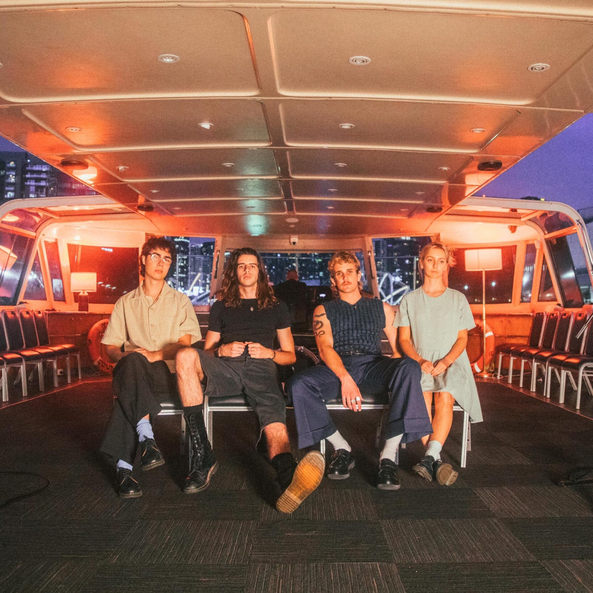 The four members of the band Spacey Jane seated on a ferry looking at the camera