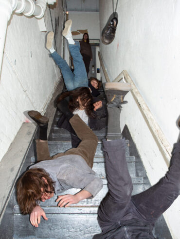The members of the band Geese, falling down the stairs