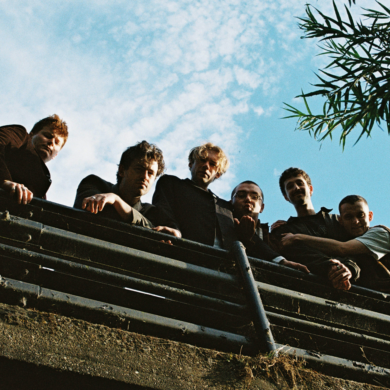 The six members of the band Flat Party looking down into the camera from a bridge